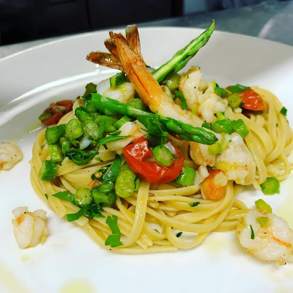 Tre Monti's Italian linguine with shrimp, asparagus, and cherry tomatoes on a white plate.